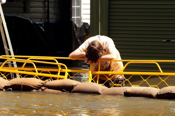 A boy takes a break from sandbagging in Numurkah during the March 2012 floods. The recent inquiry concluded that  council inaction had left the community exposed to a repeat of the flooding.