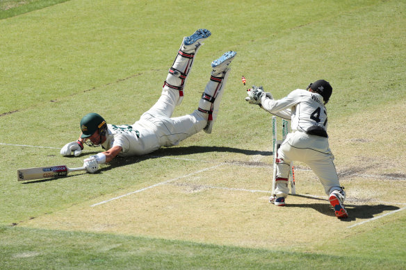 Pat Cummins, left, dives to the crease as BJ Watling, right, knocks off the bails on day two of the first Test between Australia and New Zealand. 
