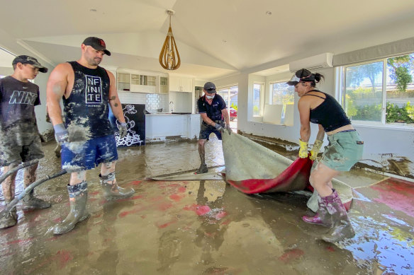 Families clean up their flood ravaged house in Napier in New Zealand’s north island after Cyclone Gabrielle struck.