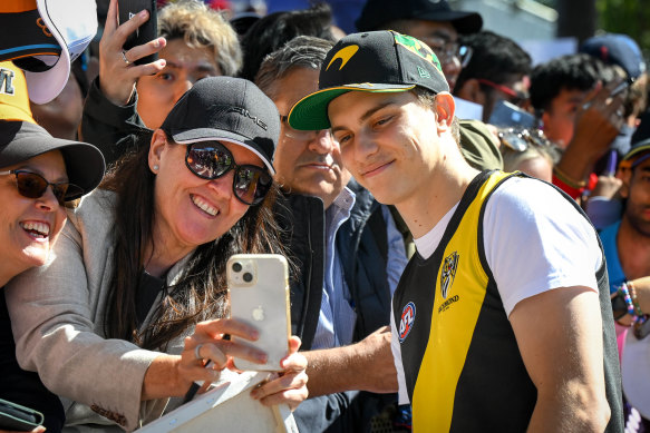 Oscar Piastri poses for a selfie with a fan.
