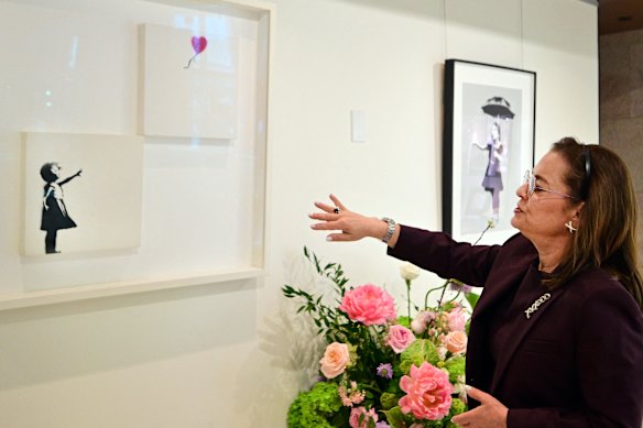 Roberta Kramer, senior vice president of Heritage Auctions, shows Banksy’s art pieces Girl with Balloon and Nola ahead of the auction.