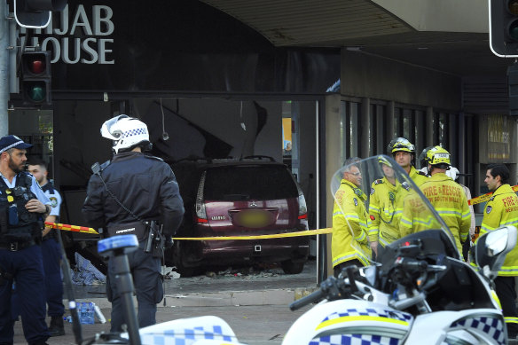 Police and emergency workers stand in front of  Hijab House in Greenacre after a car drove into a shop, injuring 14 people.