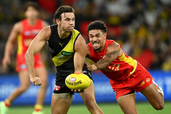 Daniel Rioli handballs while being tackled by Malcolm Rosas.