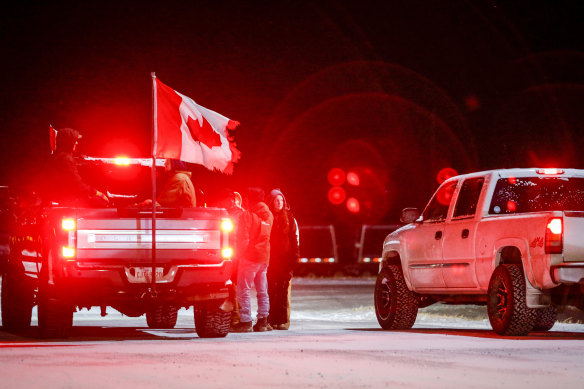 Anti-COVID-19 vaccine mandate demonstrators gather as a truck convoy blocks the highway at the US border crossing in Coutts, Alberta.
