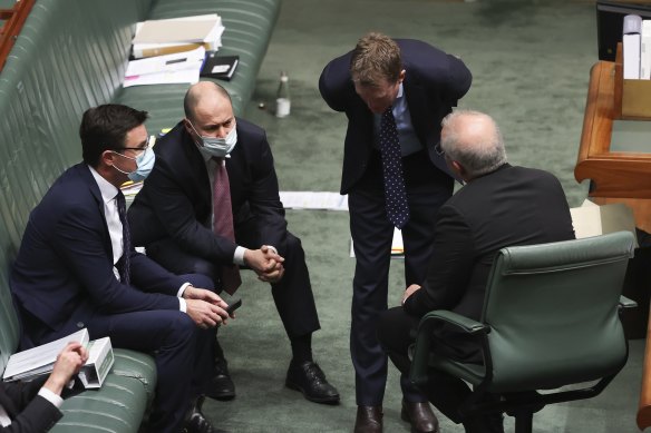 Prime Minister Scott Morrison and members of his cabinet consult during question time.