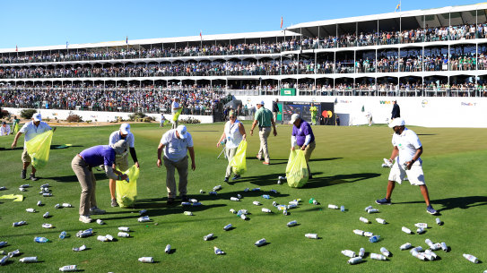 Groundskeepers clean up after the stand at the 16th erupted at Sam Ryder’s hole-in-one.