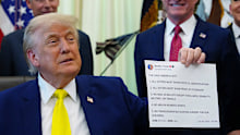US President Donald Trump holds up an image taken from his Truth Social account.