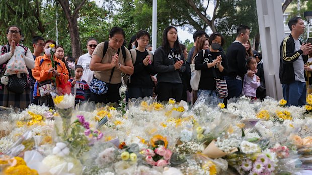 Huge crowds lay flowers to pay tribute to the victims of the Tai Po fire.