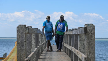 Pabai Pabai (left) and Paul Kabai on the jetty in Boigu, a low-lying island in the Torres Strait. They are taking the government to court, insisting it exercise its duty of care to them and prevent catastrophic climate change and sea level rise.  