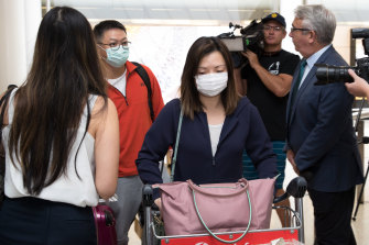 Passengers arrive at Sydney Airport from Wuhan wearing masks.