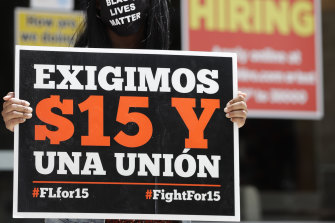 Quayneshia Smith holds a sign that says in Spanish "We Demand $15 and a Union," as she protests outside McDonald's in Fort Lauderdale, Florida.