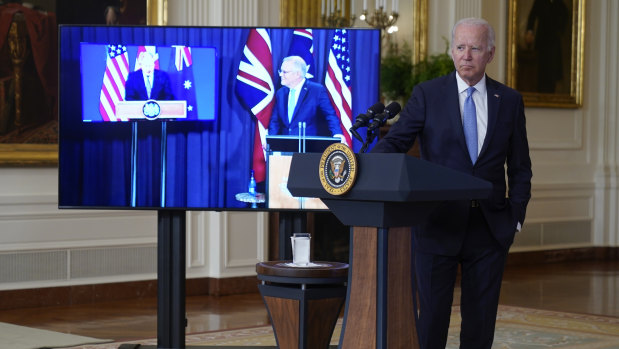 President Joe Biden, joined virtually by Australian Prime Minister Scott Morrison, right on screen, and British Prime Minister Boris Johnson, speaks about a national security initiative from the East Room of the White House.