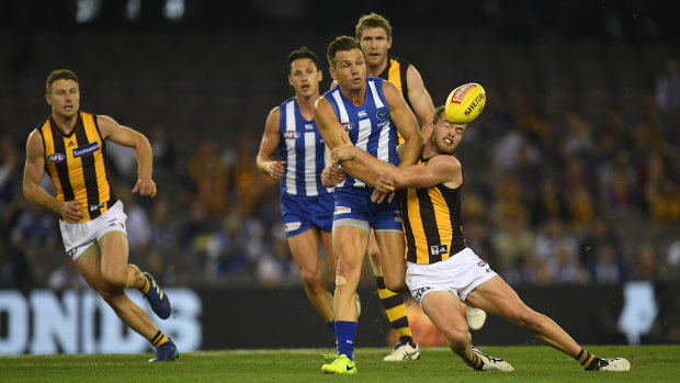 Wrapped up: Tom Mitchell  tackles North Melbourne's Shaun Higgins during the round five clash between the Roos and the Hawks.