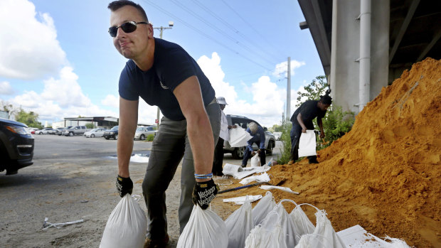 Kevin Orth loads sandbags into cars as he helps residents prepare for Hurricane Florence, in Charleston, South Carolina.