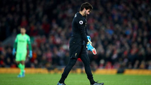 Alisson Becker of Liverpool leaves the pitch after his dismissal.