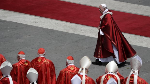 Pope Francis walks past cardinals after celebrating a Pentecost Mass in St Peter's Square at the Vatican on Sunday.