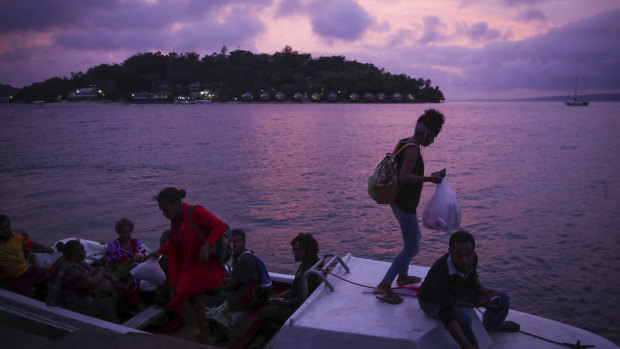 Locals board boats in Port Vila during sunset on Monday evening. 