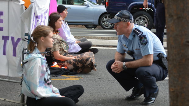 Extinction Rebellion protesters locked themselves to a barricade on the road in Brisbane's CBD on Wednesday morning.