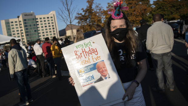 A person holds a "Very Best Birthday Present Ever" sign before an election event with US President-elect Joe Biden in Wilmington, Delaware.