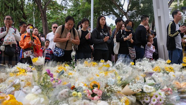 Huge crowds lay flowers to pay tribute to the victims of the Tai Po fire.