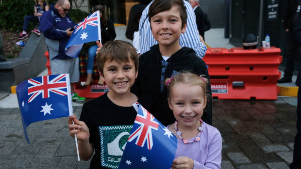 Excited attendees wave their flags at the Anzac Day March. 