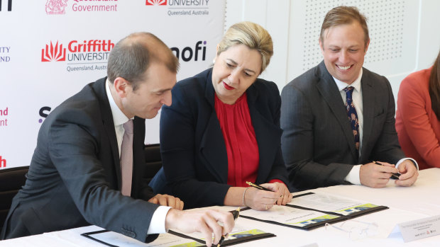 Dr Jean-Francois Toussaint from Sanofi signs the agreement with Premier Annastacia Palaszczuk and her deputy Steven Miles.