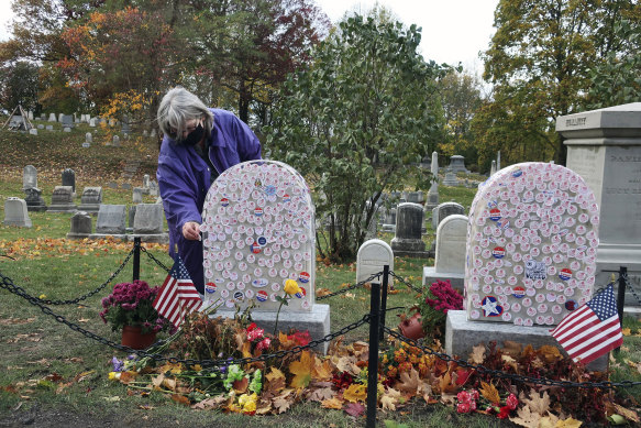 Gavin Neville, 72, places an 'I Voted' sticker on the grave of women's rights advocate Susan B. Anthony in Rochester, New York, today (Monday, US time).