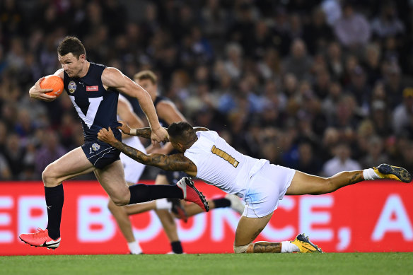 Patrick Dangerfield charges free of a tackle by the All-Stars' Michael Walters in Friday night's bushfire relief state-of-origin match at Marvel Stadium.