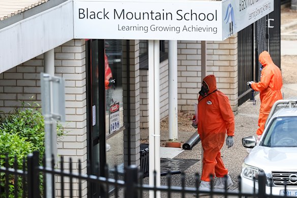 People in hazmat suits at Black Mountain School with some schools in Canberra closed due to potential asbestos contamination.