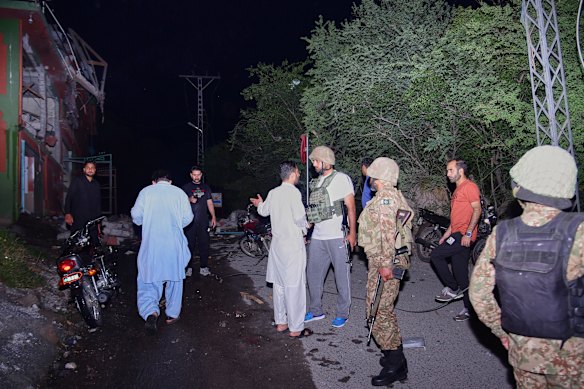 Security force officials outside a damaged building near Muzaffarabad.