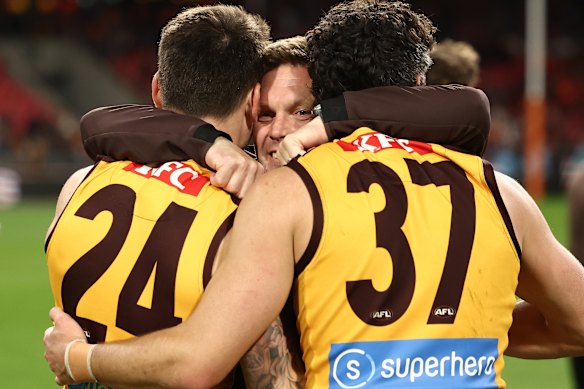 Sam Mitchell, Senior Coach of the Hawks embraces Josh Battle and Tom Barrass.