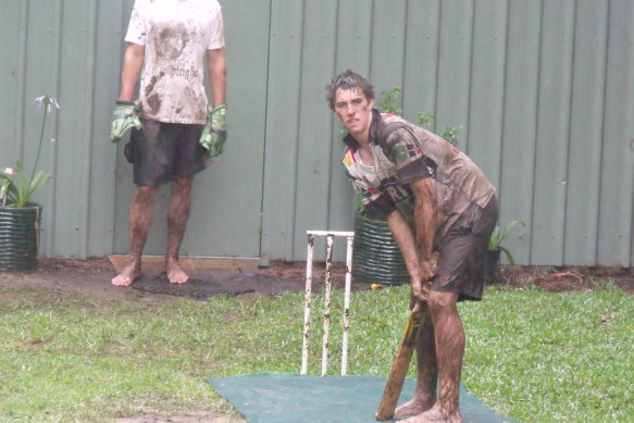 Pat bats during a muddy game in the Cummins family’s backyard.