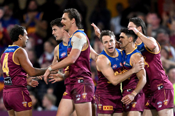 Charlie Cameron of the Lions is congratulated by teammates after kicking a goal.