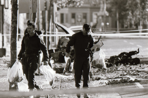 Police officers collect evidence from the car bomb explosion outside the Russell Street police station in 1986.