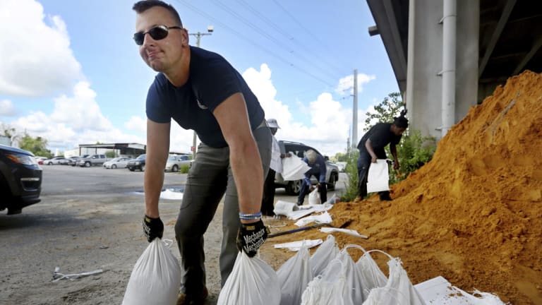Kevin Orth loads sandbags into cars as he helps residents prepare for Hurricane Florence, in Charleston, South Carolina.