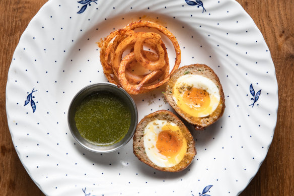 Chicken scotch egg with spicy onions.