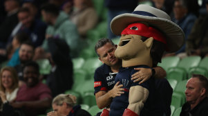 A fan hugs the Melbourne Rebels mascot.