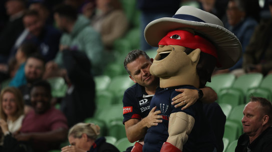 A fan hugs the Melbourne Rebels mascot.