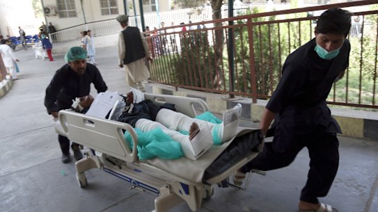 An injured man is carried into a hospital after a car bomb explosion in Kabul.