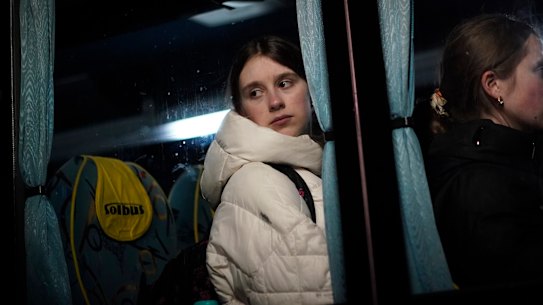 A young girl, who has fled Ukraine, looks out of the window of a bus as she prepares to travel to Przemysl after arriving at the border crossing in Medyka, Poland, on Sunday.