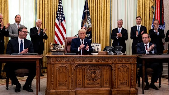 U.S. President Donald Trump, center, Aleksandar Vucic, Serbia's president, left, and Avdullah Hoti, Kosovo's prime minister, applaud following a signing ceremony in the Oval Office