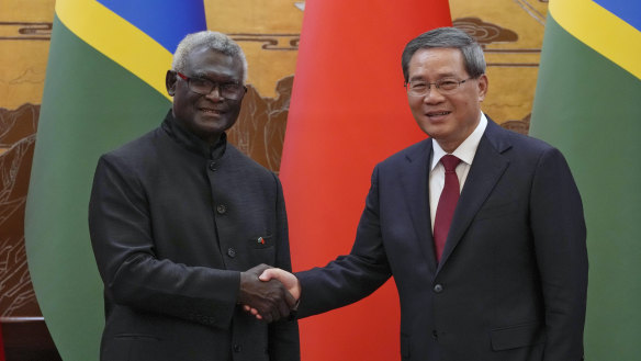 Solomon Islands Prime Minister Manasseh Sogavare, left, shakes hands with his Chinese counterpart Li Qiang  in Beijing, July 2023.