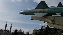 A missile is displayed in a permanent exhibition at a recreational area as minarets of a mosque are seen at rear, in northern Tehran.