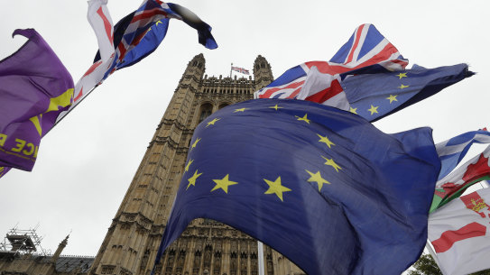 A confusion of various flags fly outside Parliament in London, Monday, Oct. 21, 2019.  The European Commission says the fact that British Prime Minister Boris Johnson did not sign a letter requesting a three-month extension of the Brexit deadline has no impact on whether it is valid and that the European Union is considering the request. (AP Photo/Kirsty Wigglesworth)