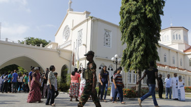 A Sri Lankan government soldier secures the premises of a Catholic church as devotees leave after Sunday Mass at a church in Colombo.