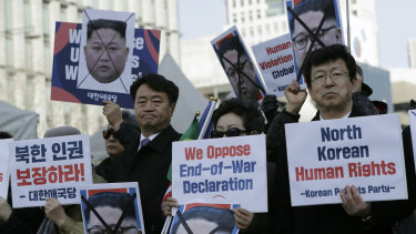 South Korean protesters and North Korean defectors hold portraits of North Korean leader Kim Jong-un during a rally urging US President Donald Trump to discuss human rights with NK's leader Kim Jong-un.