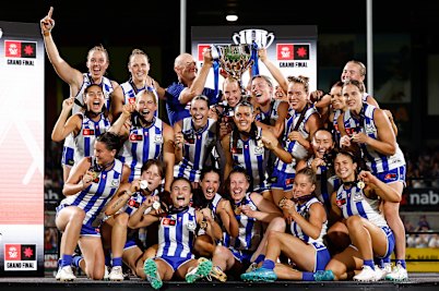 The undefeated Roos celebrate their maiden AFLW flag.