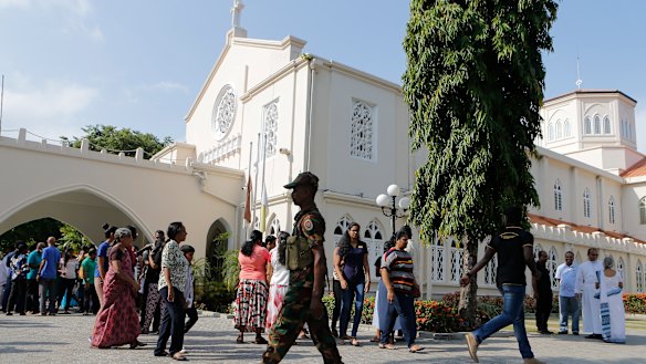 A Sri Lankan government soldier secures the premises of a Catholic church as devotees leave after Sunday Mass at a church in Colombo.