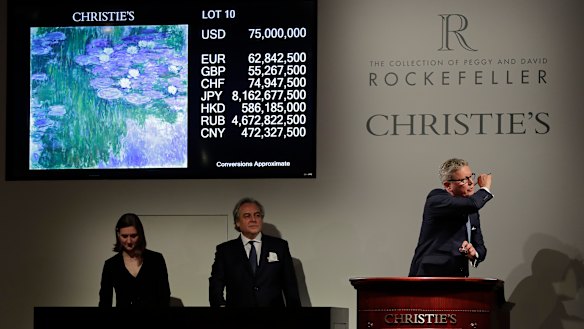 Global president of Christie's, Jussi Pylkkanen, right, taps the gavel on the podium for the final sale at $75 million of Claude Monet's "Nympheas en fleur" during an auction from the collection of Peggy and David Rockefeller on May 8.