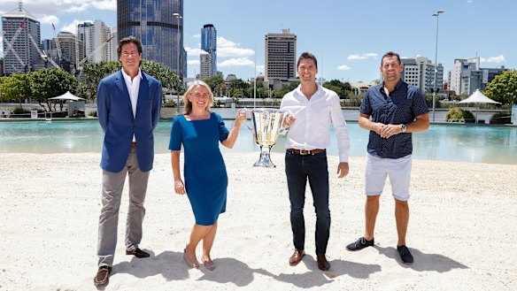 AFL chief executive Gillon McLachlan, Queensland Tourism Minister Kate Jones, former Brownlow Medallist and Brisbane Lions player Simon Black, and former Hawthorn and Brisbane Lions player Luke Hodge with the AFL premiership trophy at South Bank in Brisbane.